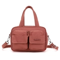 Detalle de bolso de nailon rosa palo con múltiples bolsillos y correa ajustable - Rojo Baya