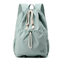Detail view of mint green nylon backpack with drawstring pockets and cream cotton cords - Soft Mist Green