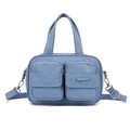 Detailed macro view of dual front zipper pockets on blue nylon functional handbag - Iris Blue