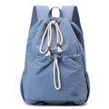 Close-up of light blue nylon drawstring backpack with cotton rope and brand label - Iris Blue