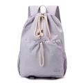 Detailed close-up of light purple nylon drawstring backpack with front pocket and side pouch - Lavender