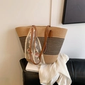 Strohtasche mit schwarzen Streifen und rosa Blumenstickerei auf schwarzer Bank - Braun
