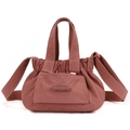 Detail view of nylon crossbody bag featuring drawstring pleats and magnetic flap pocket - Berry Red