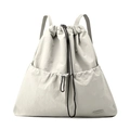 Detail of grey water-resistant nylon drawstring backpack with front pocket and brand label - Bone White