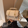 Cream white crossbody messenger bag with golden buckle and top handle shown in studio - Off White
