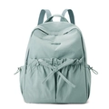 Detailed view of mint green nylon backpack featuring ruffle edges and a cute bow tie accent - Soft Mist Green