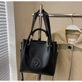 Detail of black faux leather tote bag with circular star logo and gold hardware - No Pendant / Black