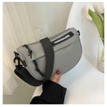 Detalle del bolso de silla en nailon gris con correa ancha negra y logo de moda - Gris