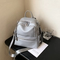 Light gray pebbled leather backpack with silver zippers and multi-functional straps - Gray