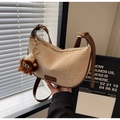 Detail of woven straw hobo bag featuring brown leather trim and cute plush bear charm - Cream White With Pendant