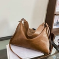 Minimalistische braune Hobo-Tasche aus Leder mit matter Textur und breitem Schultergurt - Braun