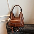 Borsa hobo vintage in pelle marrone con ciondolo a cane su divano in pelle nera - Marrone con ciondolo