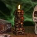 Macro detail of vintage bronze skull stack with glowing flame for Halloween decor - Bronze