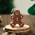Brown gingerbread man scented candle with white festive details on a wooden base - Brown