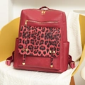 Detalle de la mochila burdeos con estampado de leopardo en una silla de hogar - Rojo