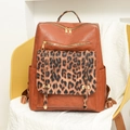 Detalle de mochila de cuero marrón con un elegante bolsillo frontal con estampado de leopardo - Marrón