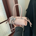 Rosa Boston-Tasche mit silbernen Schleifen-Anhängern und Bändern in der Hand - Rosa (mit Anhänger)
