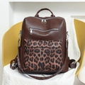 Dettaglio di uno zaino in pelle marrone con un'elegante tasca frontale con stampa leopardata - Marrone