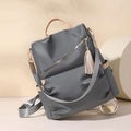 Detail of dark grey nylon anti-theft backpack with brown leather trim and tassel - Gray