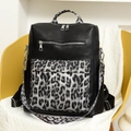 Dettaglio dello zaino in pelle PU nera con tasca leopardata grigia su sedia gialla - Nero