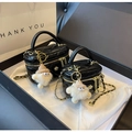 Detail of black quilted mini vanity case with gold chain strap and fluffy charm in a gift box - Large / With Charm / Black