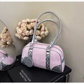 Dettaglio borsa Boston rosa marmorizzata con tocchi argento su libri eleganti - Rosa
