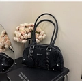 Dettaglio borsa Boston nera con texture increspata, occhielli argento e logo BOCILEE inciso - Nero