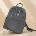 Dettaglio dello zaino in nylon impermeabile grigio scuro con texture liscia e zip argentate - Grigio