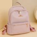 Close-up of litchi grain faux leather and golden kangaroo logo on pink backpack - Pink