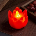 Close-up of a red LED lotus candle with a warm flickering flame on a bamboo mat - Red