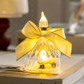 Dekorative LED Flammenlose Kerze mit Kristallsockel und elegantem cremefarbenem Band - Transparent