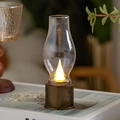 Retro LED Kerosin-Nachtlicht mit Bronzesockel und warmer Flamme auf einem Buch - Bronze