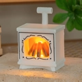 Close-up of mini dollhouse fireplace lamp with warm LED light and vintage scroll patterns - White