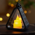 Macro view of triangular retro LED lantern with matte black frame and warm flickering candle - Black