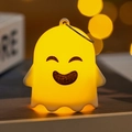 Close-up of a glowing yellow ghost LED night light with a hanging metal ring for Halloween - Smiling Ghost (A)