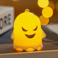 Close-up of glowing yellow silicone Halloween ghost pendant with funny face and hook - Funny Ghost (C)