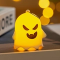 Nahaufnahme eines warmgelben leuchtenden Geist-Ornaments mit Aufhängering für Halloween - Wütender Geist (E)