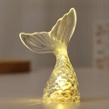 Close-up of a mermaid tail LED night light with warm glow and textured scale patterns - Transparent Warm White Light