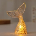 Macro shot of mermaid tail night light with gold glitter and glowing warm yellow base - Glitter Yellow Light