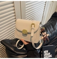 Detail of cream leather flap bag featuring golden square lock and pearl charm accessory - Beige With Charm