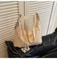 Detail der beigen Hobo-Tasche mit dekorativen geflochtenen Seilanhängern und mattem Leder - Gebrochenes Weiß