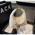Detalle de bolso hobo crema con letras en relieve y hebilla dorada en caja de regalo - Blanco Roto