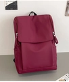 Détail du sac à dos en nylon bordeaux avec fermeture à rabat et poche latérale utile - Rouge