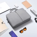 Gray business laptop bag with durable fabric shown with office accessories and gadgets - Gray