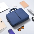 Flat lay of navy blue business laptop bag with side accessories on grey background - Blue