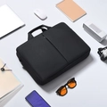 Business laptop bag surrounded by professional office accessories on light background - Black