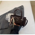 Detail of dark brown leather crossbody bucket bag with tennis racket charm and silver buckle - With Pendant / Coffee
