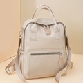 Dettaglio dello zaino in nylon beige con tasca frontale con cerniera e tasca laterale elastica - Bianco Sporco