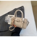 Detail of cream white PU leather bucket bag with racket charm on gray blazer - With Pendant / Off White