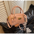 Dettaglio borsa boston in vernice rosa chiaro con placca e ciondolo intrecciato - Rosa
